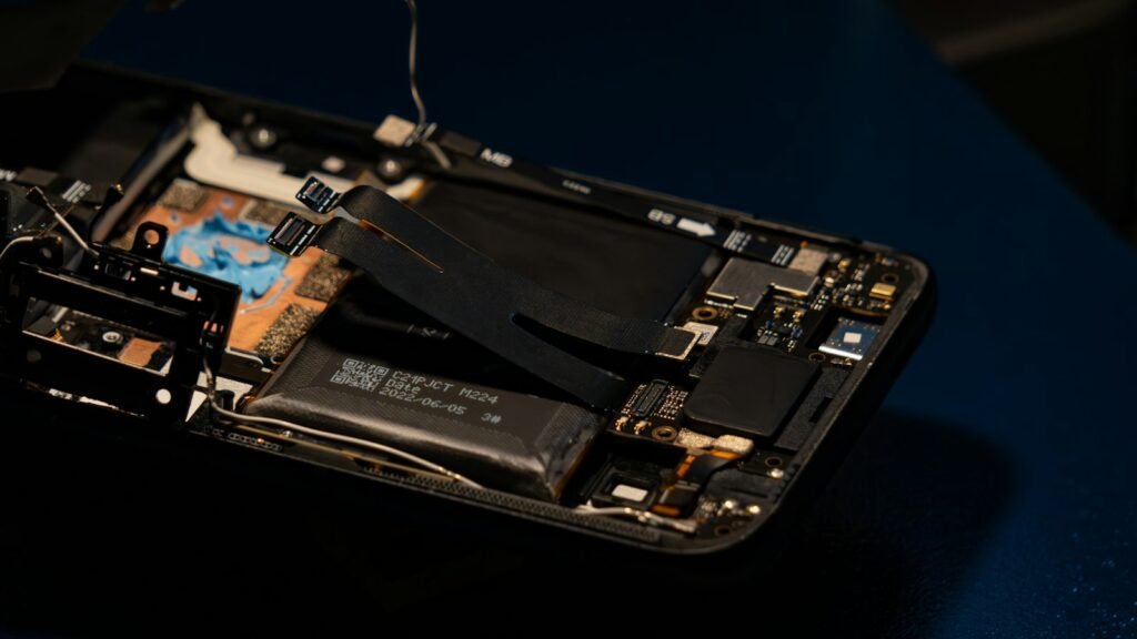 Smartphone démonté laissant voir ses composants électroniques et sa batterie
