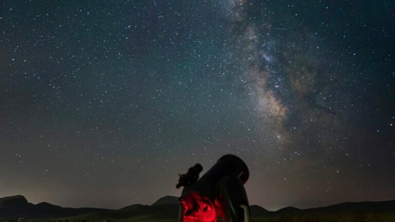 Télescope sur trépied dans un champ sous un ciel nocturne étoilé